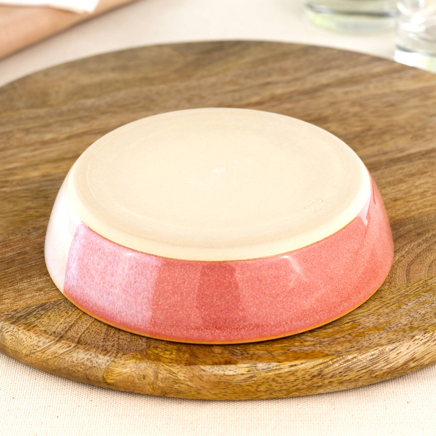 Base of a wheel-thrown tapas bowl in Coral & White, showing the smooth burnished foot and makers mark, handmade in a small Sussex pottery studio