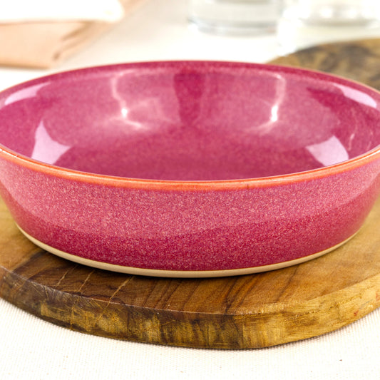 Close-up of a handmade stoneware tapas bowl in Crimson, highlighting the glossy speckled glaze, rich red tones and flatter shape designed for tapas-style serving