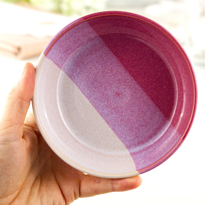 Handmade ceramic tapas bowl held in the hand, finished in Crimson & White glazes and designed for dips, olives, side dishes and sharing food