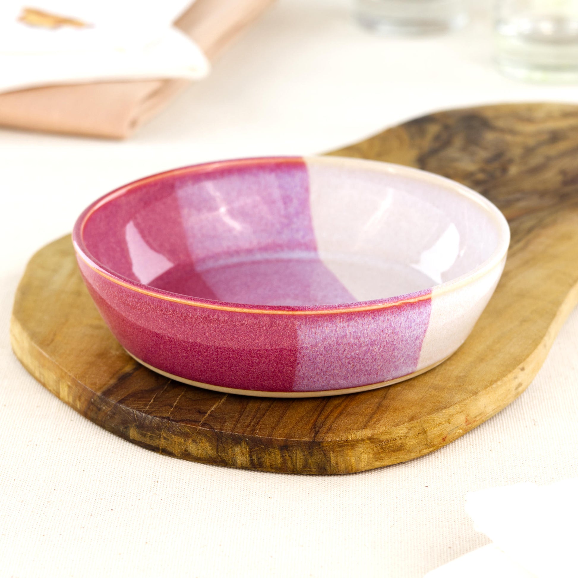 Wheel-thrown Crimson & White tapas bowl on an olive wood board, a piece of British studio pottery for tapas-style serving, grazing platters and everyday artisan tableware