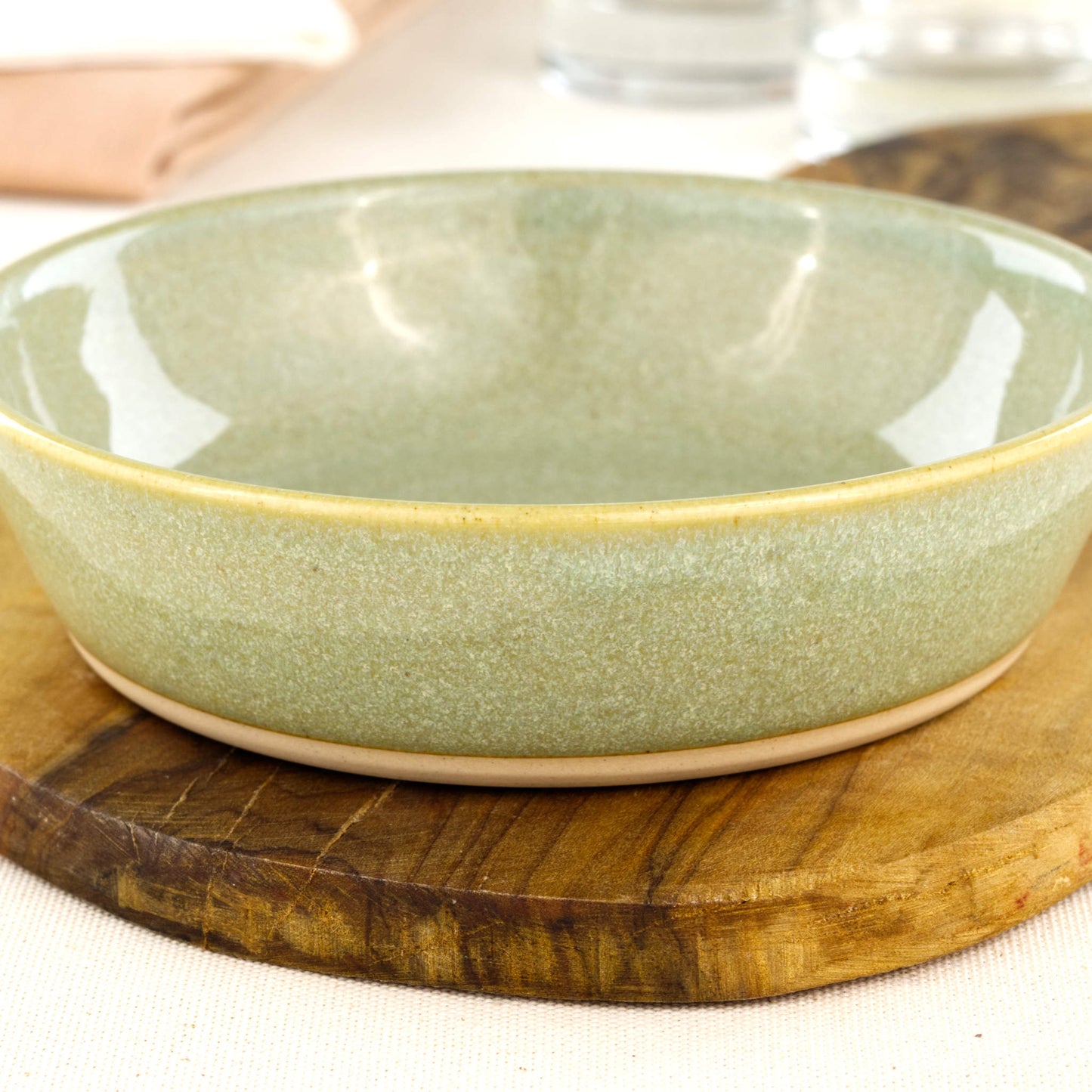 Close-up of a handmade stoneware tapas bowl in Pale Green, highlighting the glossy speckled glaze, artisan finish and flatter shape designed for tapas-style serving