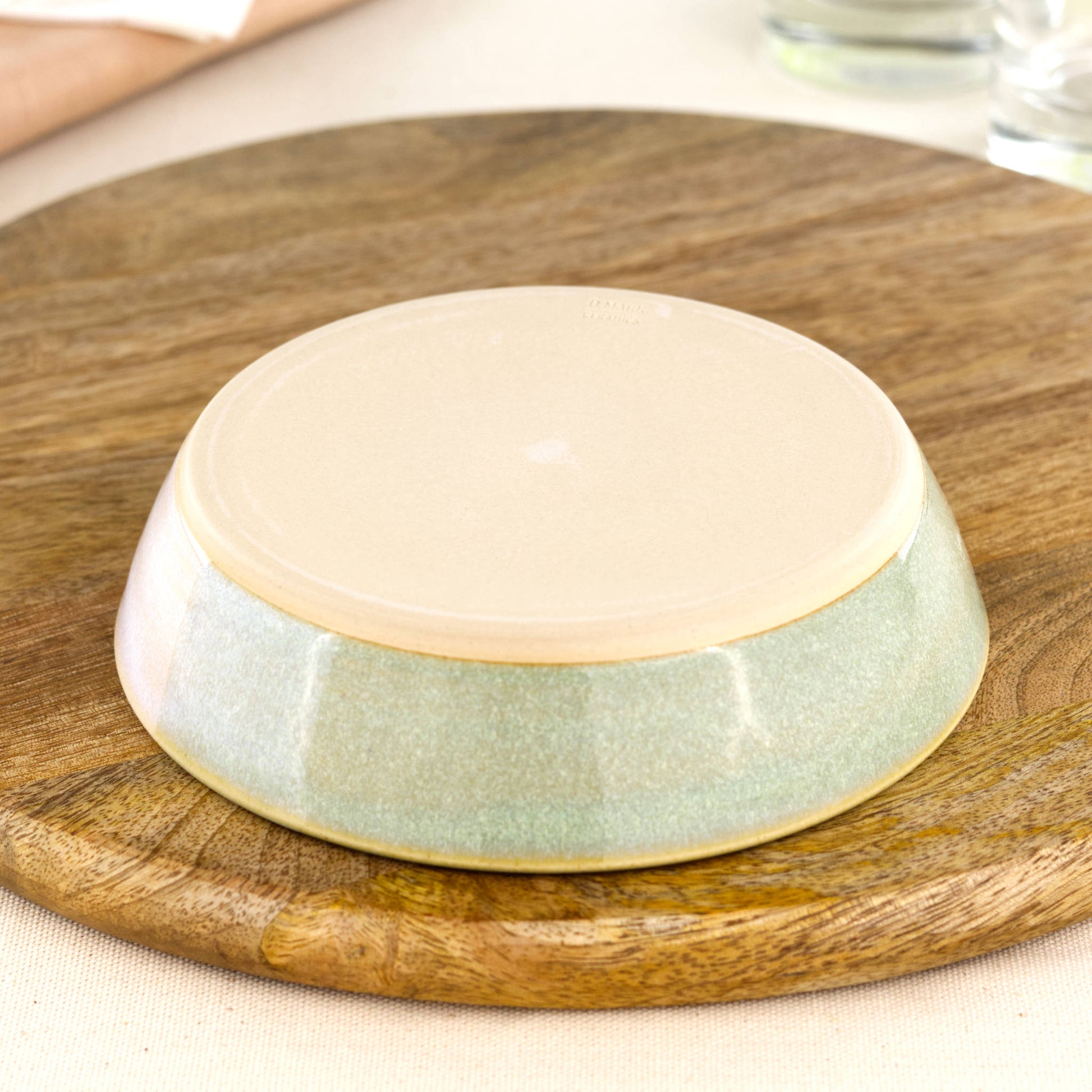 Base of a wheel-thrown tapas bowl in Pale Green & White, showing the smooth burnished foot and makers mark, handmade in a small Sussex pottery studio