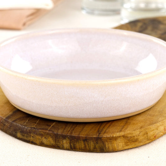 Close-up of a handmade white stoneware tapas bowl, highlighting the glossy speckled glaze, simple artisan finish and shallow shape designed for tapas-style serving